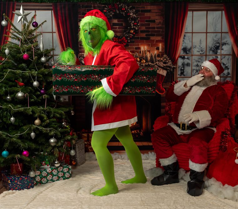 Grinch stiehlt ein Geschenk, der Weihnachtsmann schaut erschrocken zu – Weihnachtsset im Studio
