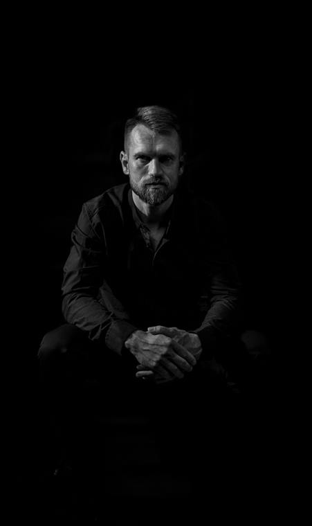 Marcus Friebel, Fotograf, sitzend im dunklen Studio
