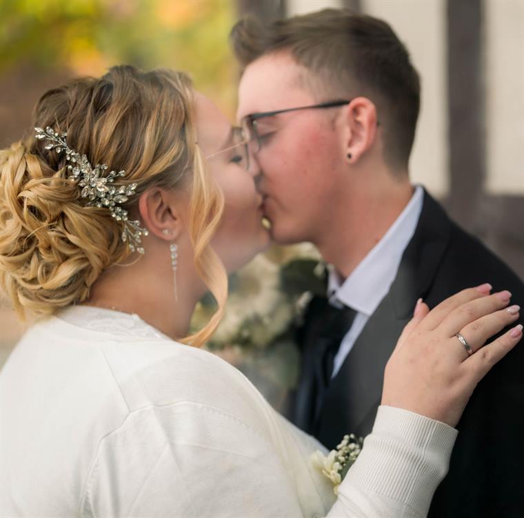 Brautpaar im Kuss, Blumen im Haar der Braut