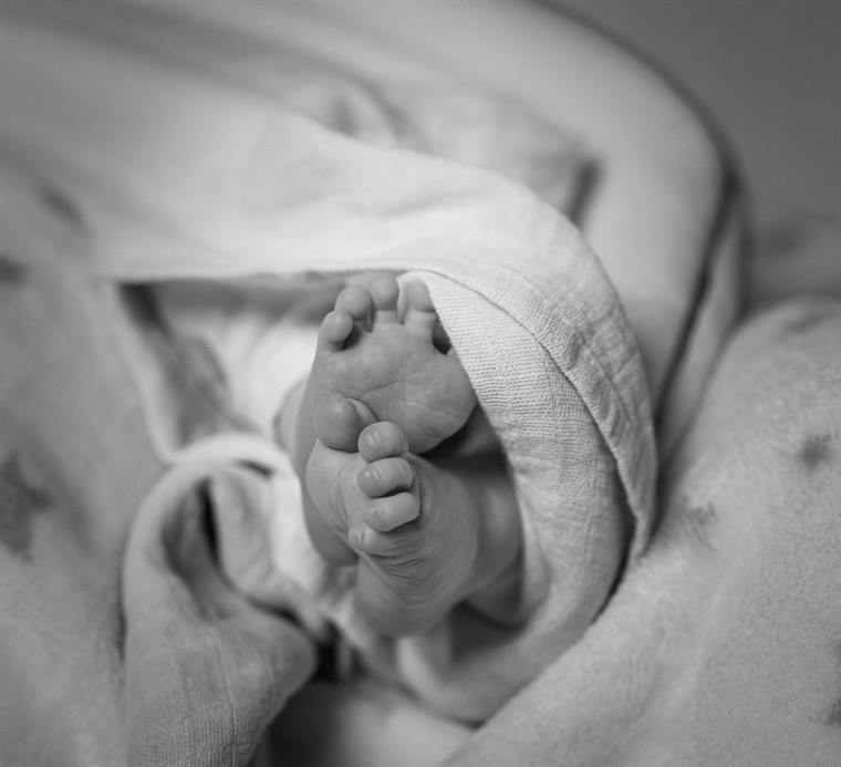 Babyfüße unter einem Tuch, schwarzweiß