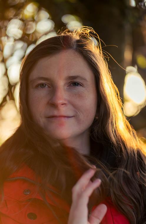 Frau in roter Jacke im warmen Abendlicht