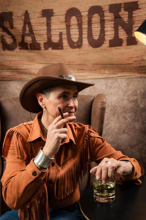 Mann mit Hut und Zigarre in Saloon-Kulisse