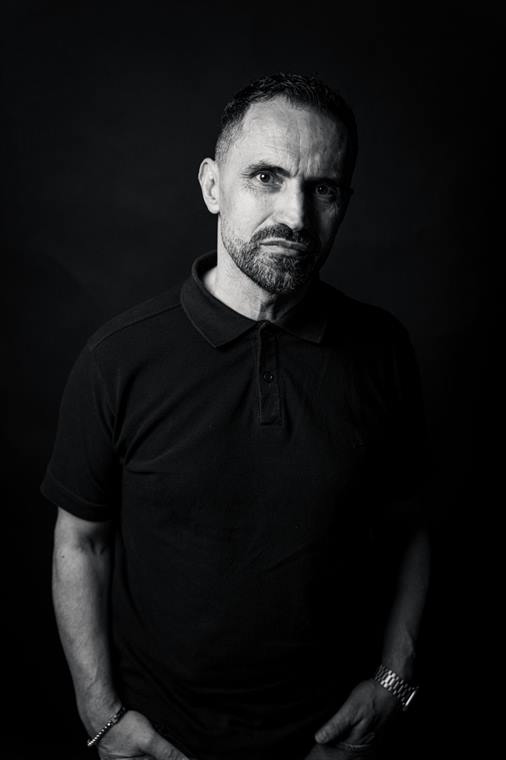 Mann im schwarzen Polohemd, Low-Key-Portrait